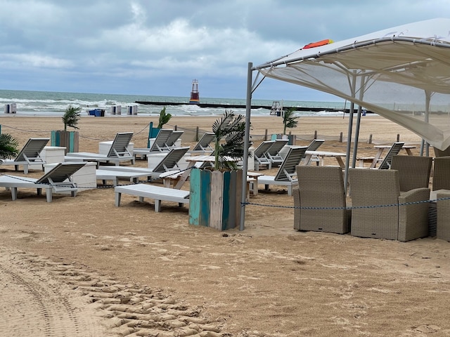 view of home's community featuring a water view and a beach view