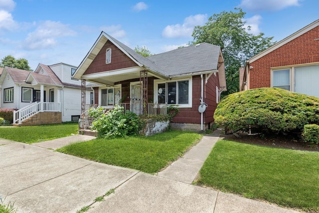 bungalow with a porch and a front lawn