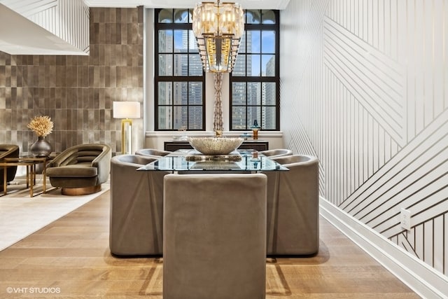 interior space featuring a healthy amount of sunlight, a chandelier, tile walls, and light hardwood / wood-style floors