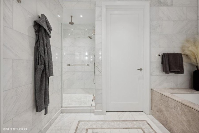 bathroom featuring a shower with shower door, tile patterned flooring, and tile walls