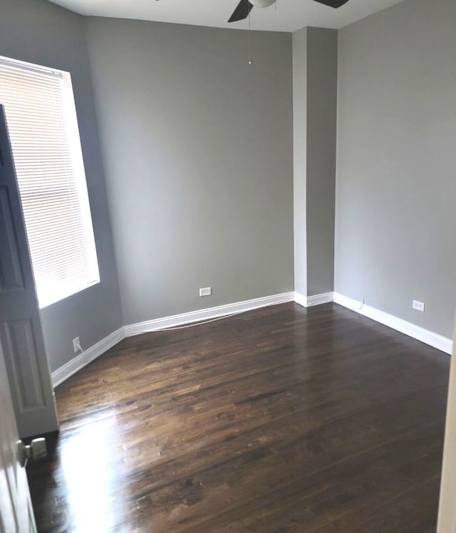 unfurnished room featuring ceiling fan and dark wood-type flooring