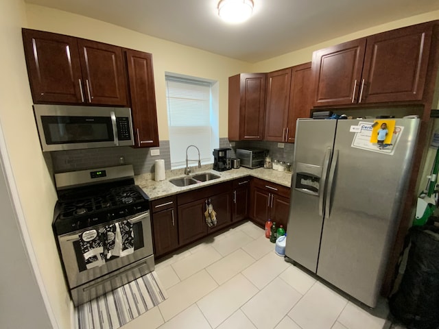 kitchen with decorative backsplash, sink, light tile patterned floors, and stainless steel appliances