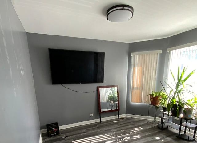 interior space with dark hardwood / wood-style flooring and ornamental molding