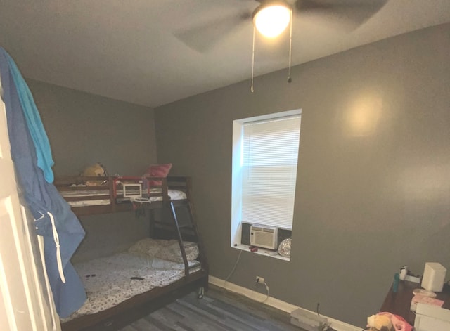 bedroom with ceiling fan, cooling unit, and dark hardwood / wood-style flooring