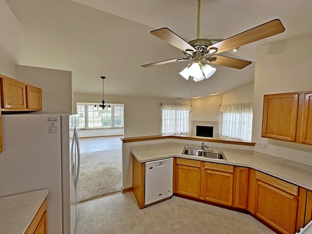 kitchen featuring ceiling fan with notable chandelier, white appliances, sink, pendant lighting, and lofted ceiling