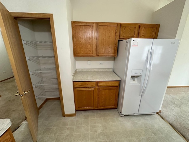 kitchen with white refrigerator with ice dispenser