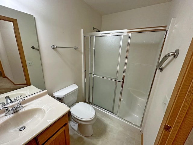 bathroom with vanity, toilet, and a shower with door