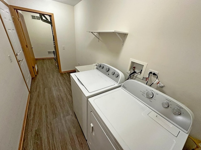 laundry room with hardwood / wood-style floors and washing machine and dryer