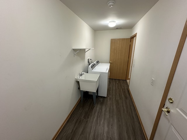 laundry room with dark hardwood / wood-style flooring, separate washer and dryer, and sink