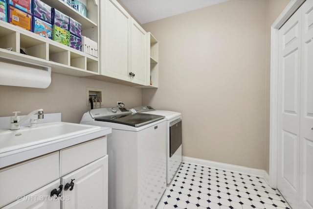 laundry room featuring cabinets, sink, and washing machine and clothes dryer