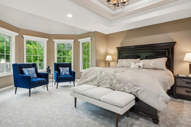 carpeted bedroom with a raised ceiling, an inviting chandelier, and ornamental molding