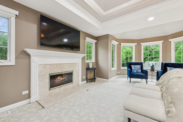 living room with a fireplace, a raised ceiling, and ornamental molding