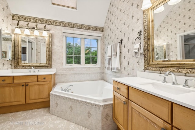 bathroom with tiled tub, tile patterned flooring, and vanity