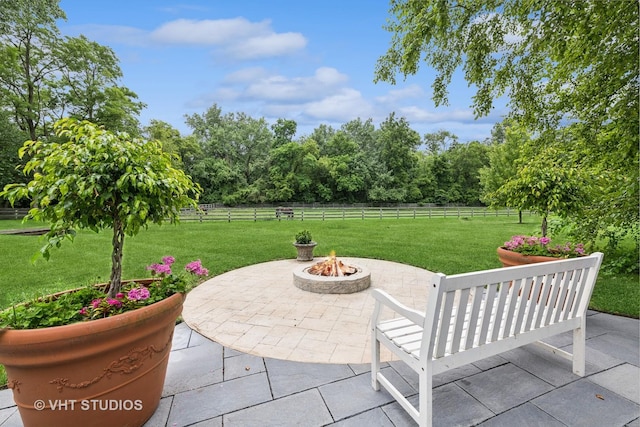 view of patio with a rural view and a fire pit