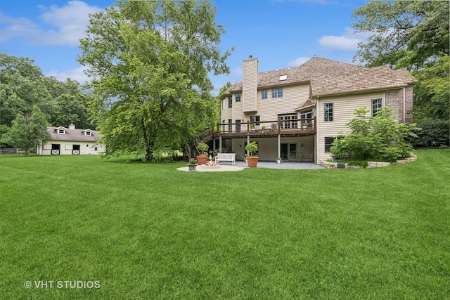 back of property featuring a lawn, a patio area, and a wooden deck