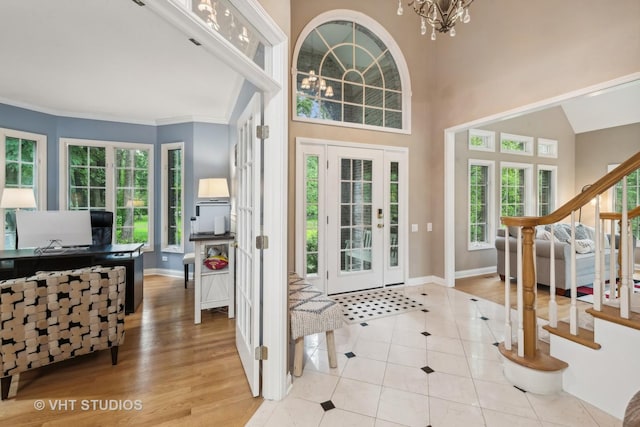 foyer featuring light tile patterned floors, ornamental molding, and an inviting chandelier