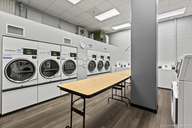 laundry area featuring a towering ceiling, dark hardwood / wood-style flooring, and washer and clothes dryer