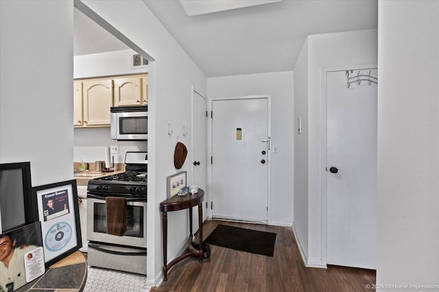 kitchen with appliances with stainless steel finishes and dark hardwood / wood-style flooring