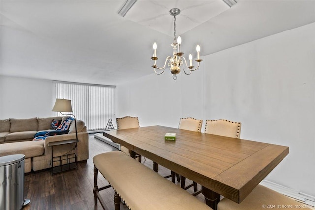 dining area featuring dark wood-type flooring and a chandelier