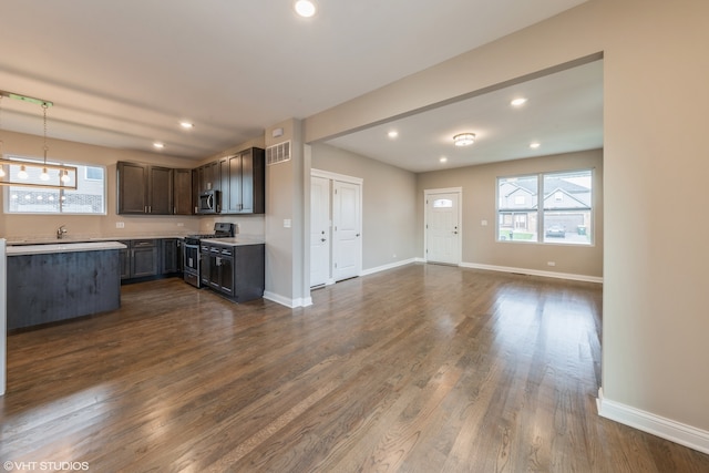 unfurnished living room featuring dark wood-type flooring and sink