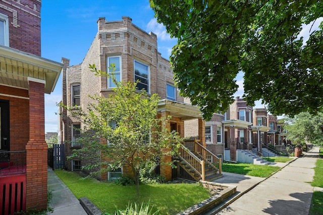 view of front facade with a front yard and brick siding