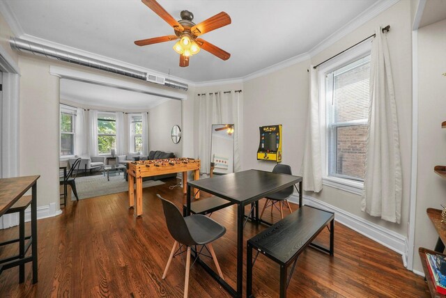 dining room with ceiling fan, dark wood-type flooring, and crown molding