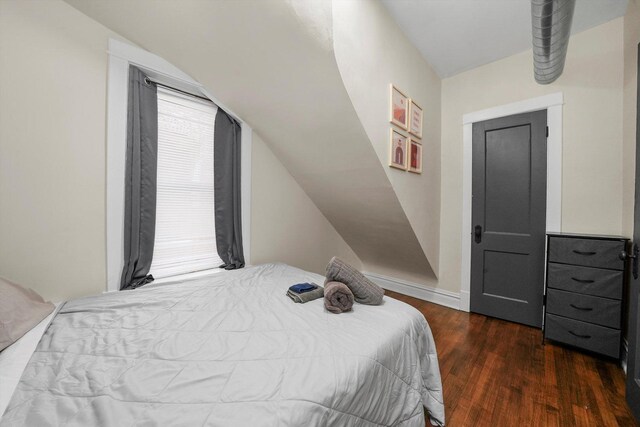 bedroom featuring dark hardwood / wood-style flooring and lofted ceiling