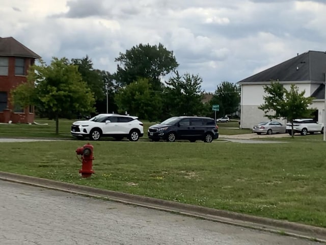 view of parking / parking lot featuring a yard