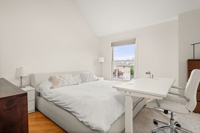 bedroom featuring light wood-type flooring and vaulted ceiling