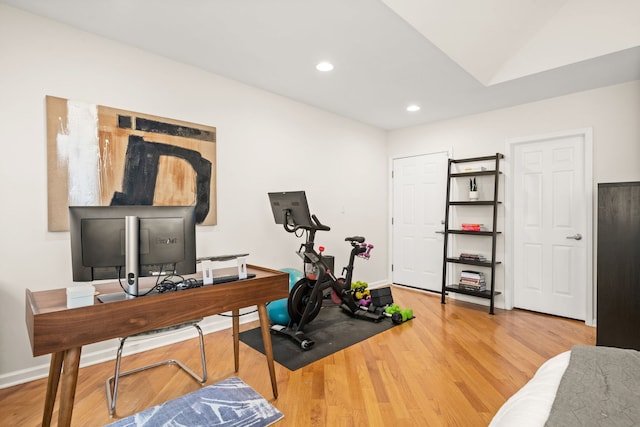 exercise room with light hardwood / wood-style floors