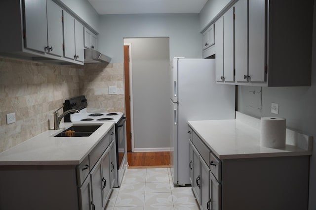 kitchen with gray cabinets, sink, light tile patterned floors, and white appliances