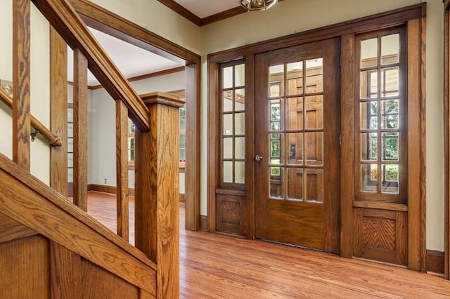 foyer featuring crown molding and light hardwood / wood-style floors