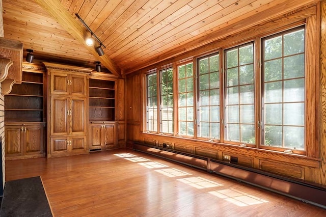 unfurnished living room with hardwood / wood-style flooring, plenty of natural light, wood ceiling, baseboard heating, and track lighting