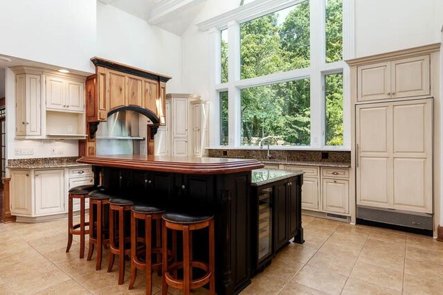 kitchen featuring light tile patterned flooring, a kitchen island, and a high ceiling