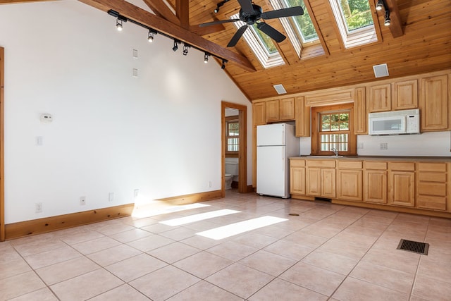 kitchen featuring ceiling fan, high vaulted ceiling, white appliances, a skylight, and light tile patterned floors