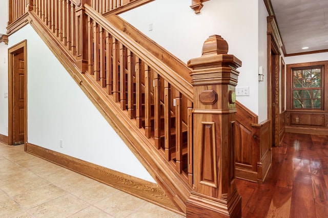 stairs featuring wood-type flooring and ornamental molding