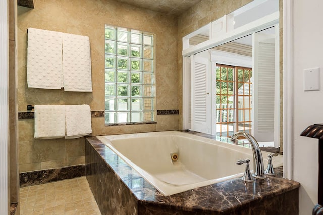 bathroom with tile patterned flooring, tile walls, and tiled tub