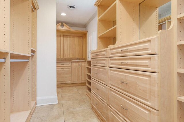 walk in closet featuring sink and light tile patterned floors