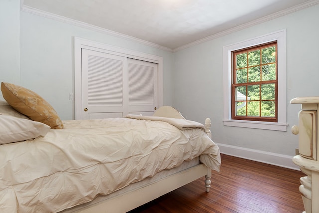 bedroom with a closet, crown molding, and dark wood-type flooring