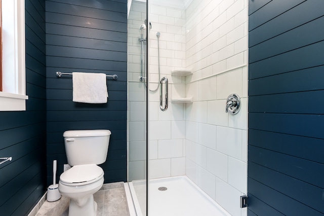 bathroom with a shower with shower door, tile patterned floors, and toilet