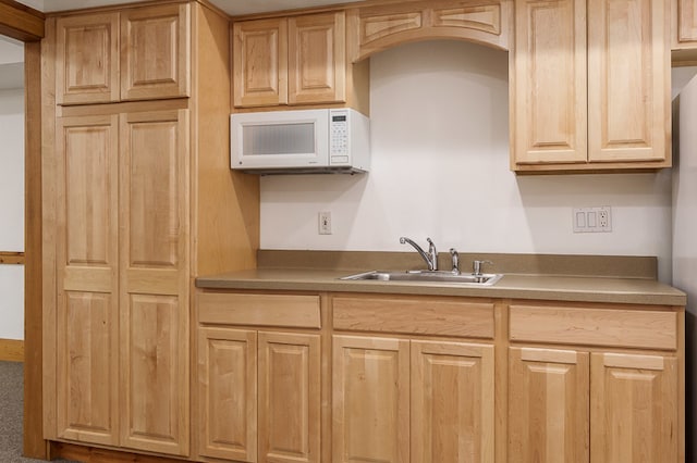 kitchen featuring light brown cabinetry, sink, and carpet flooring