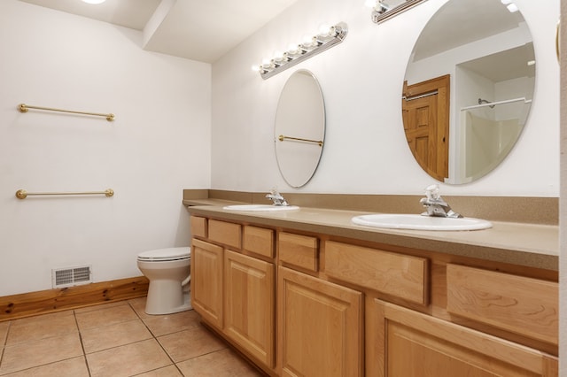 bathroom featuring tile patterned flooring, dual bowl vanity, and toilet