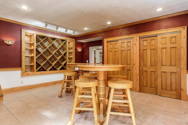 interior space featuring bar, rail lighting, and light tile patterned floors