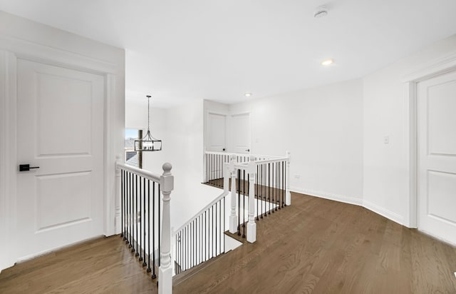 corridor featuring dark wood-type flooring and a chandelier