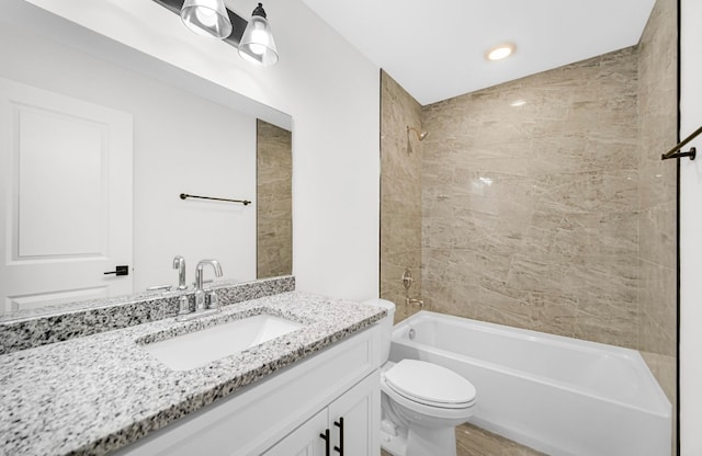 full bathroom featuring tiled shower / bath combo, vanity, and toilet