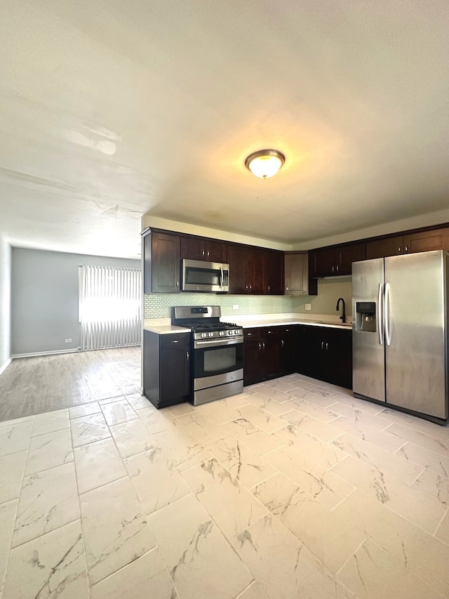 kitchen featuring light tile patterned flooring, stainless steel appliances, dark brown cabinets, and sink