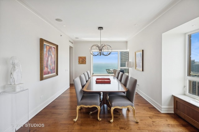 dining space with a water view, crown molding, hardwood / wood-style flooring, and a healthy amount of sunlight