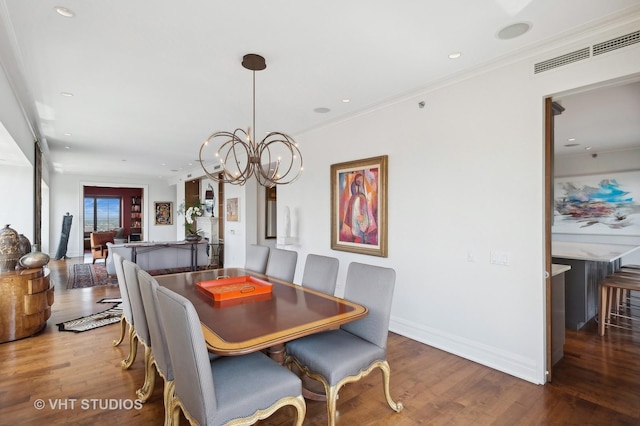 dining space featuring hardwood / wood-style flooring, crown molding, and a chandelier