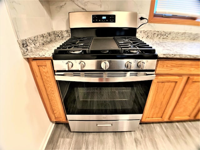 kitchen featuring gas stove and light hardwood / wood-style flooring