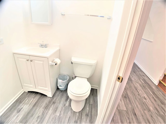 bathroom featuring vanity, hardwood / wood-style flooring, and toilet